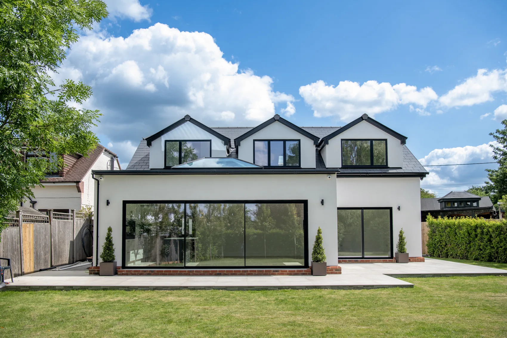 Rear elevation of the development &mdash; full-width sliding glazing onto the landscaped garden